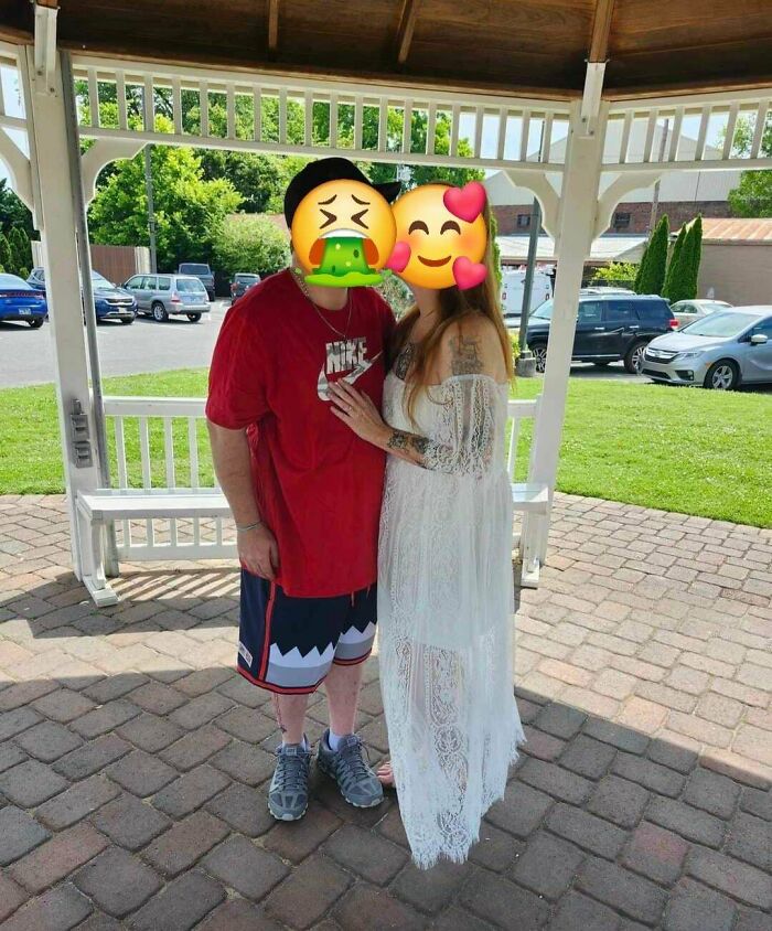 Couple at an outdoor wedding, one in casual attire and the other in a lace dress, under a gazebo.