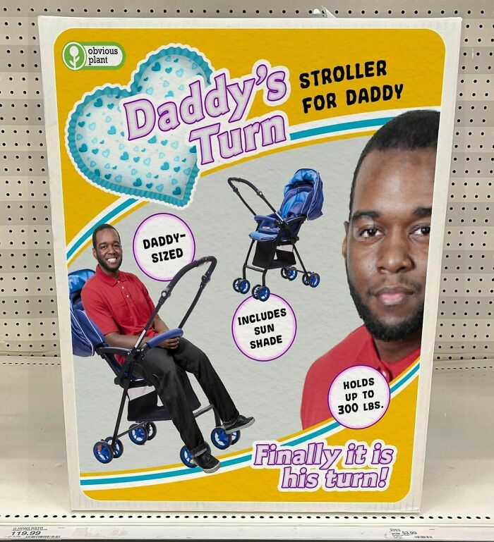Fake product display of a "Daddy's Turn" stroller by Obvious Plant, humorously sized for adults in a store setting.