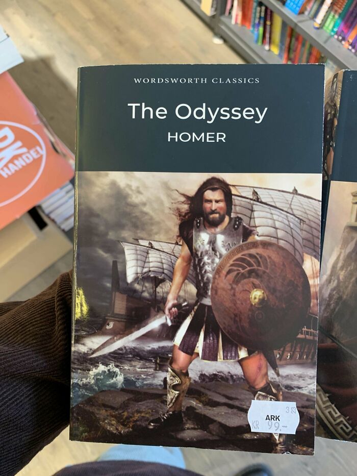 The Odyssey book cover with a warrior holding a shield and sword, standing by a ship; a notable terrible book cover.
