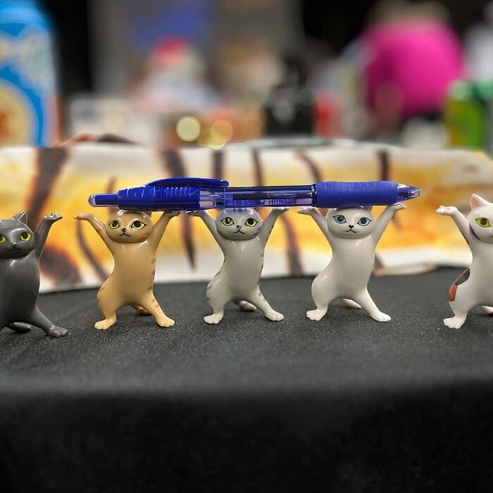 Cute cat figurines holding a blue pen, perfect for work supplies to brighten up your Monday.