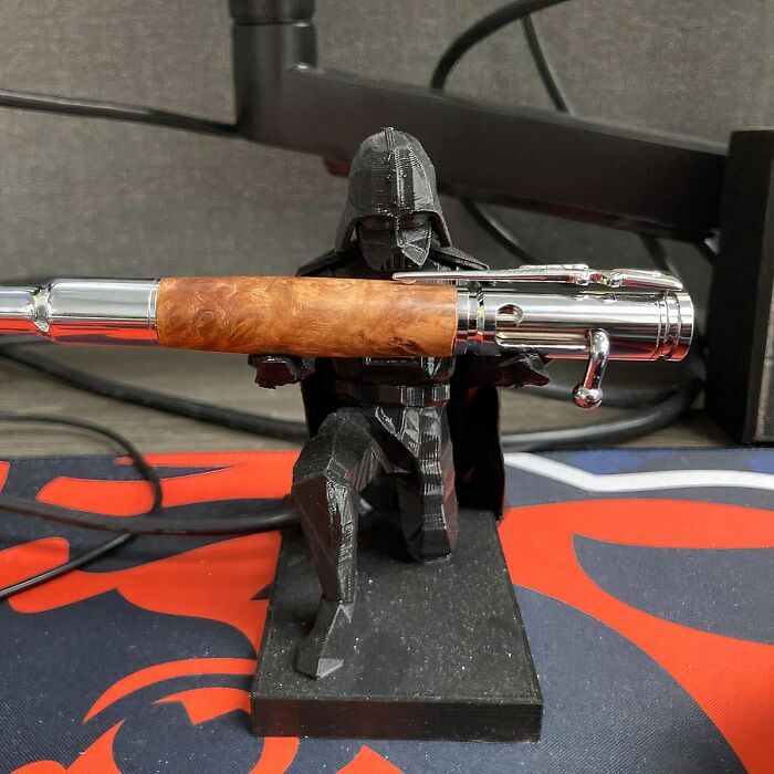 Star Wars-themed pen holder with a cape-clad figure, a unique work supply that enhances desk aesthetics.