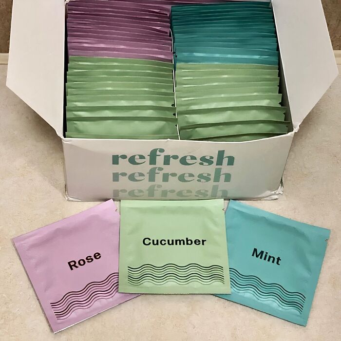 Travel essentials: individual refresh wipes in rose, cucumber, and mint scents displayed with packaging.