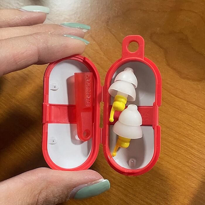 Earplugs in a red case, a useful travel item to avoid common mistakes.