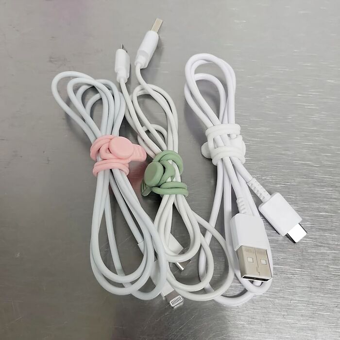 Travel items: three white charging cables with colorful organizers.
