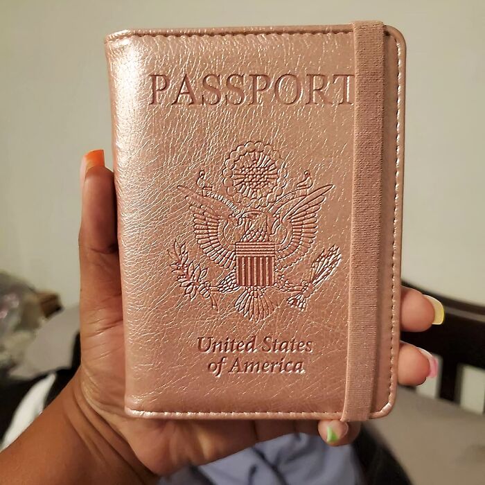 A hand holding a US passport holder, one of the items to avoid common travel mistakes.