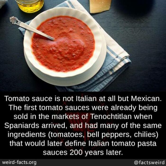 Bowl of tomato sauce on a table with a spoon, highlighting a weird fact about its Mexican origins.