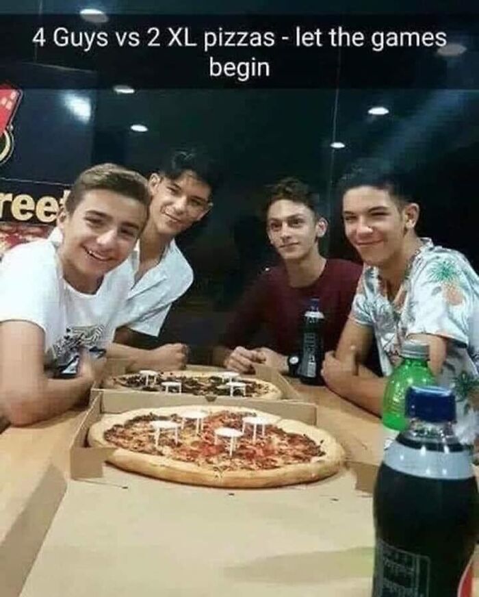 Four friends with two XL pizzas, ready for a fun challenge at a dining table.