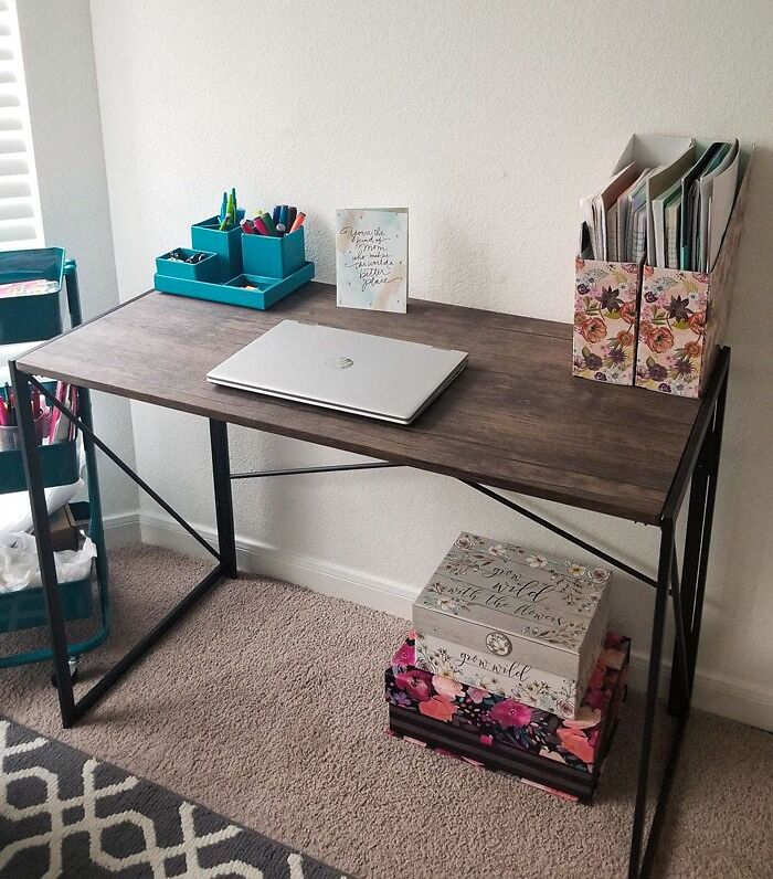 Minimalist tiny apartment furniture desk with laptop, colorful stationery organizer, and floral storage boxes in compact space.
