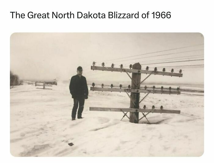 Historic image of the Great North Dakota Blizzard 1966 showing deep snow and a man near a telephone pole winter landscape, history facts.