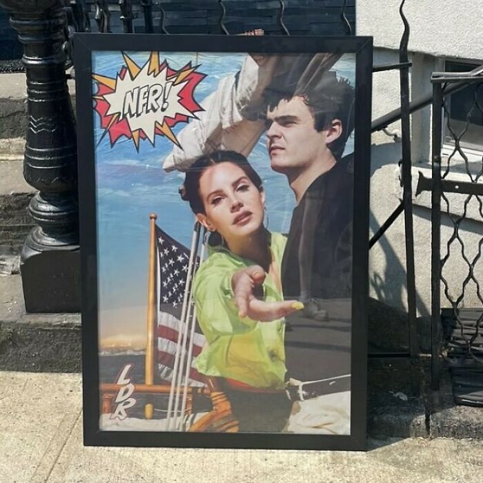 Framed artwork left on NYC curb, featuring a colorful pop-art style with two figures and an American flag.