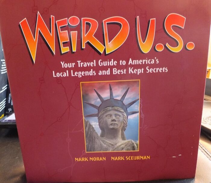 Book cover of Weird U.S. travel guide featuring America's local legends and amazing discoveries with a Statue of Liberty close-up.