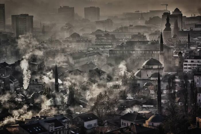 Cityscape shrouded in mist and smoke, showcasing a dramatic and breathtaking landscape from the 2024 ReFocus Awards.