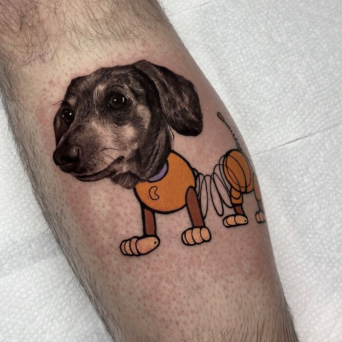 Tattoo of a realistic dog head seamlessly merging with an artistic cartoon body on a person's leg.