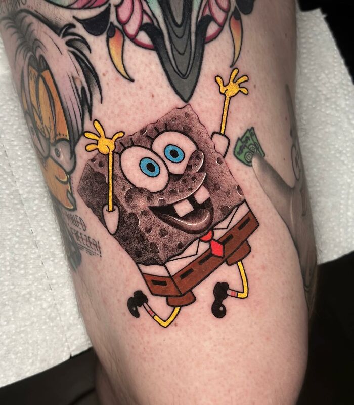 Tattoo of Spongebob Squarepants creatively merges two artistic styles on someone's leg.