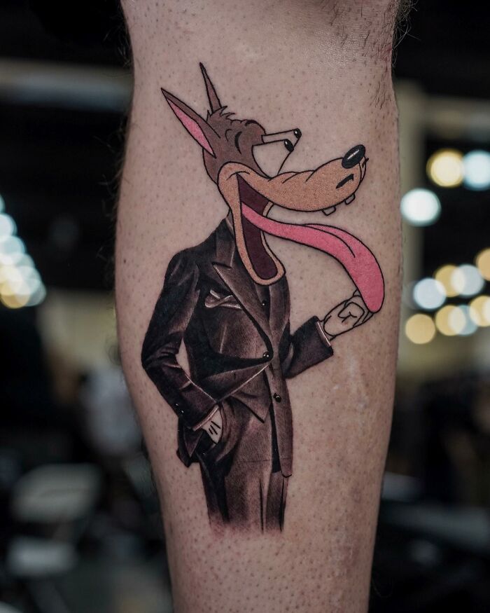 Tattoo of a cartoon wolf in a suit on forearm, merging two artistic styles seamlessly.
