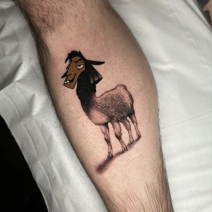 Tattoo merging two artistic styles on a person's calf, featuring a cartoon llama with realistic fur details.