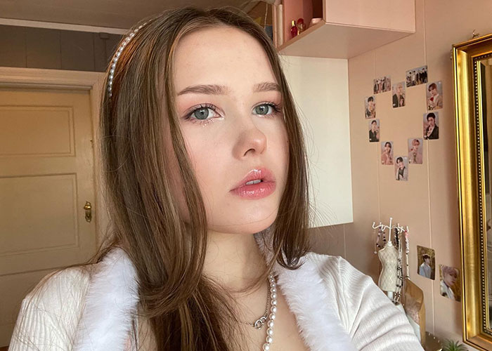 Young woman indoors, looking baffled, capturing the moment strangers start having a picnic in her yard.