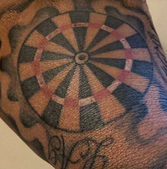 Tattoo depicting a black and red dartboard, noted as uncomfortable for the artist to create.