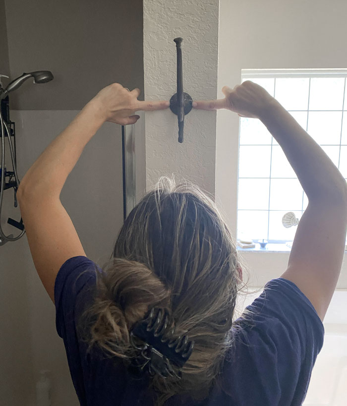 My Wife Is Using Her Tools To Make Sure The Hook Is Even On The Wall