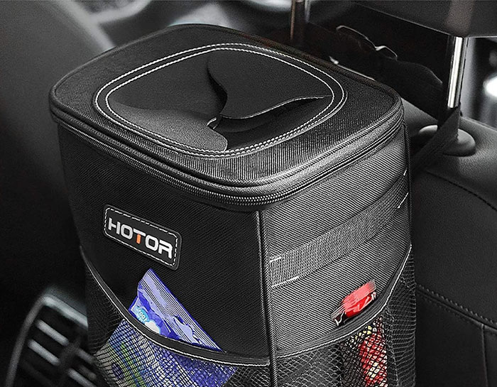 Car item: a black, compact car trash bin with a lid installed in the rear seat area.