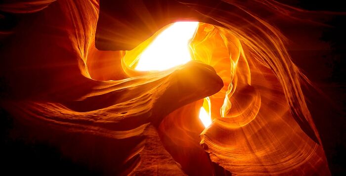 Sunlight streaming through narrow canyon walls, highlighting natural rock formations that evoke frightening vacation stories.