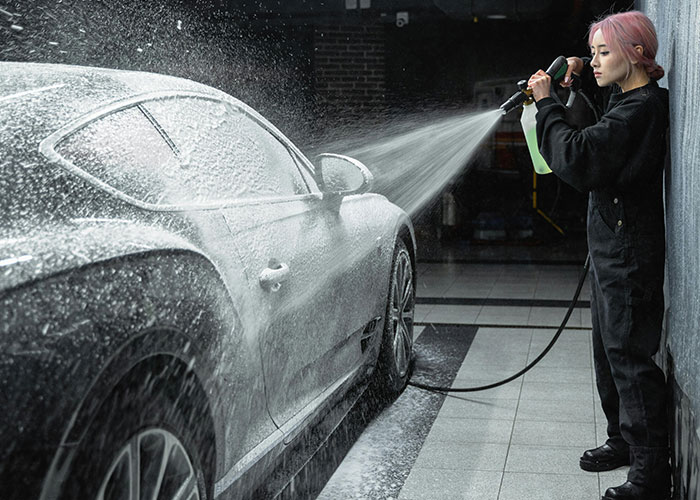Person washing a car with a high-pressure hose, illustrating everyday things most people don’t realize are deadly.