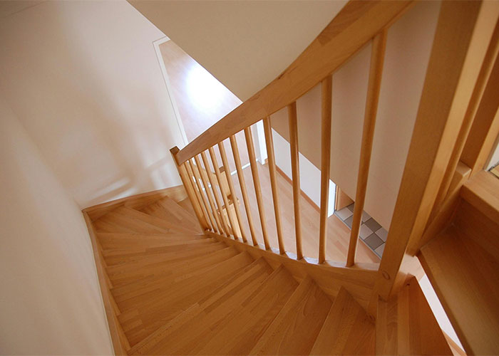 Wooden indoor staircase with railing, illustrating one of the everyday things most people don’t realize are deadly.