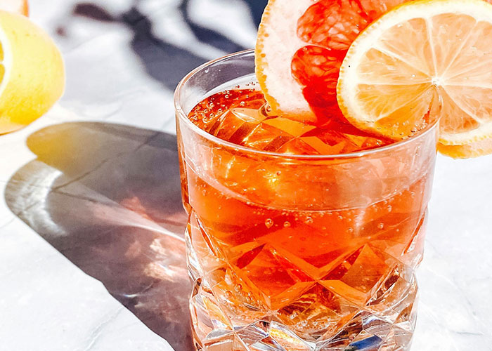 Glass of iced drink with slices of citrus fruit, highlighting everyday things most people don’t realize are deadly.