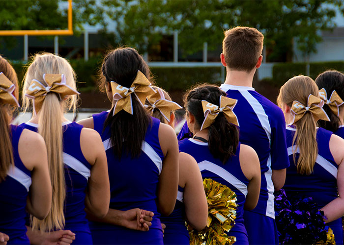 Group of cheerleaders standing outdoors in uniforms, highlighting caution about everyday things that are deadly.