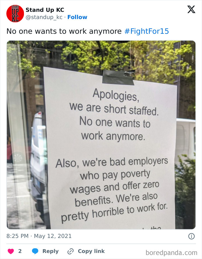 Sign mocking "no one wants to work" trend, admitting poor wages and staff shortages on a window.