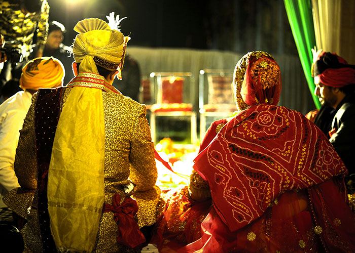 Bride and groom in traditional attire at a wedding ceremony, reflecting cultural practices and traditional wives experiences.