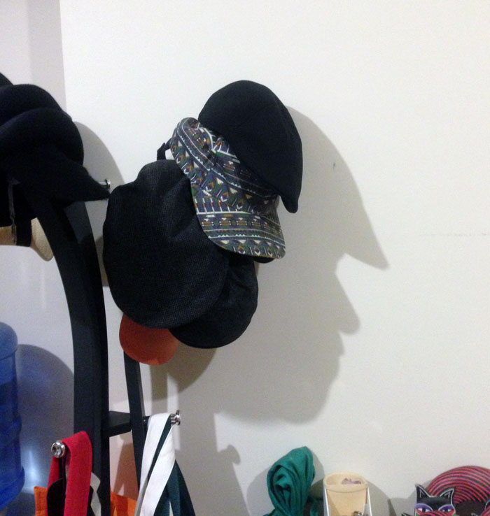 The Hats On This Hatrack Cast A Shadow In The Shape Of A Face