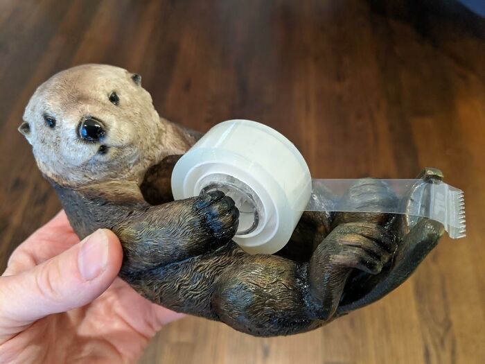 Otter tape dispenser held in hand, playful addition to Office Olympics and workday fun.