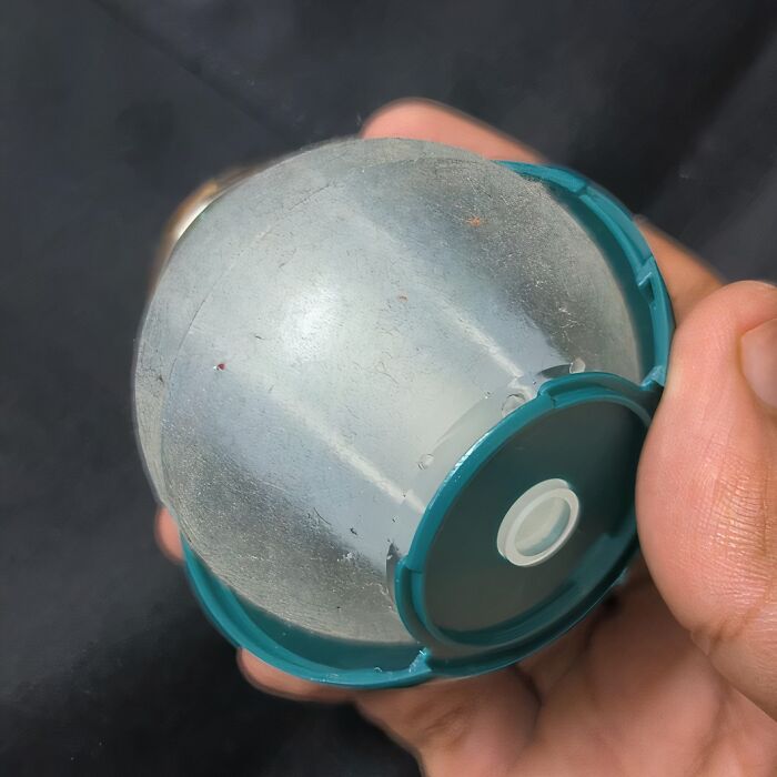 Hand holding an internet-famous cleaning tool with a round, transparent, and plastic design.