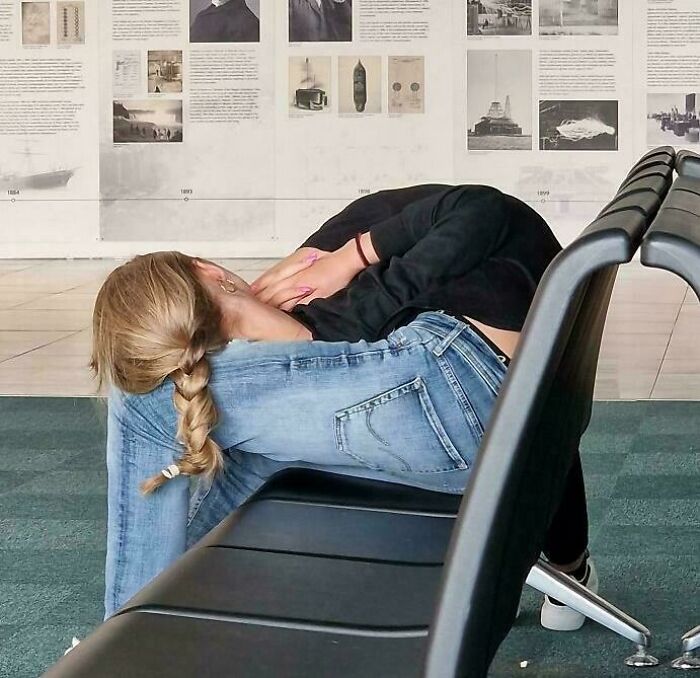 Confusing image of person sitting in an unusual position on airport chairs, appearing visually perplexing.