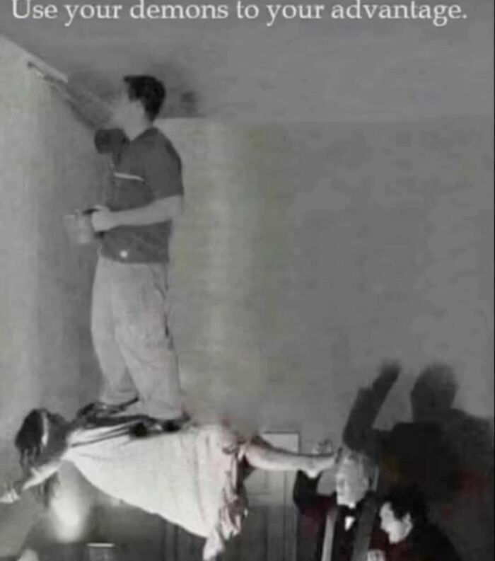 Man humorously using levitating woman to paint ceiling, embodying random memes that are unexpectedly funny.