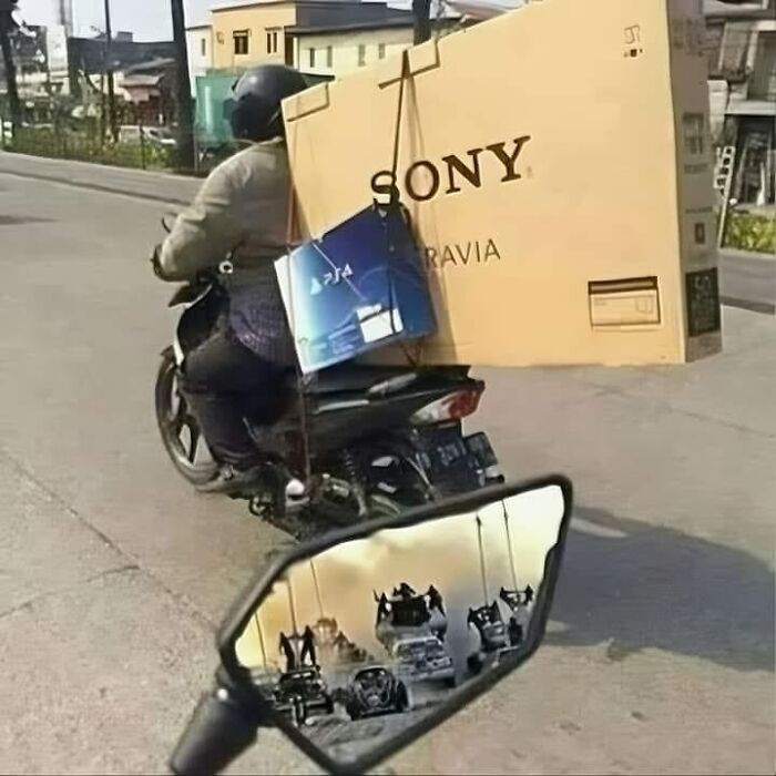 Motorbike with large Sony box and PS4, mirror reflects "Mad Max" style chase. Pics that go hard.