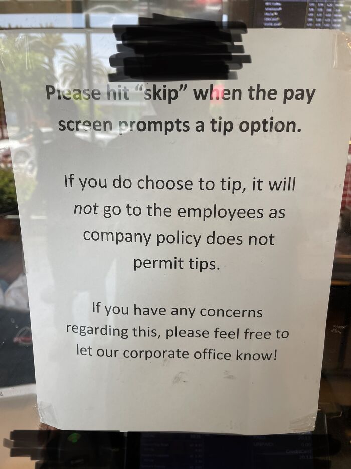 Sign instructing customers to skip tipping as company policy prohibits tips, highlighting the ridiculous capitalism practices.