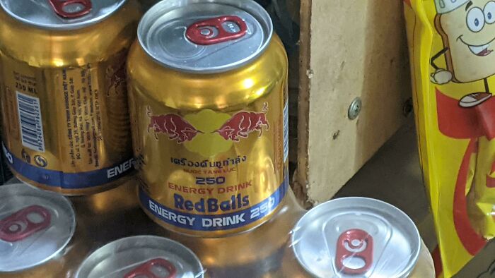 RedBalls energy drink can with logo and text displayed among other similar cans on a store shelf, showing brand rip-off.