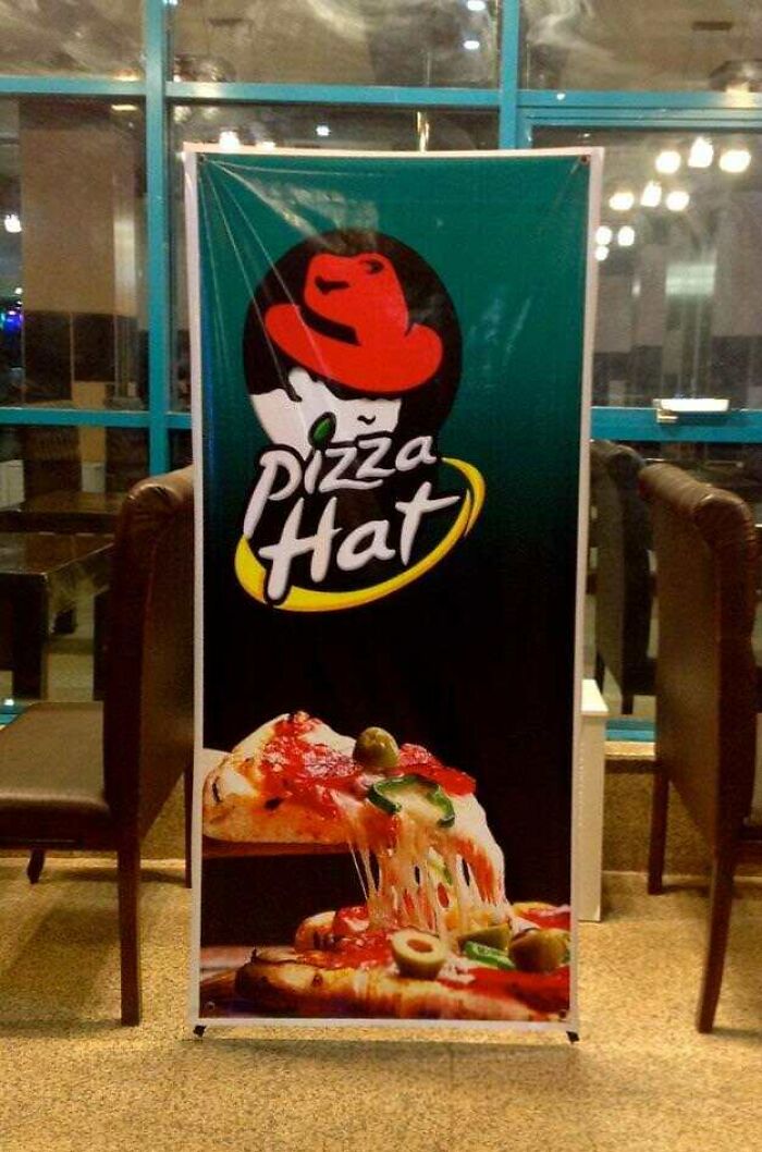 Signboard showing a hilariously bad rip-off of a well-known pizza brand with melted cheese and toppings.