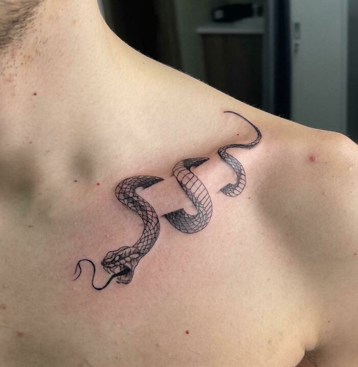 Intricate snake tattoo design on shoulder showcasing tattoo artists' creativity and precision.