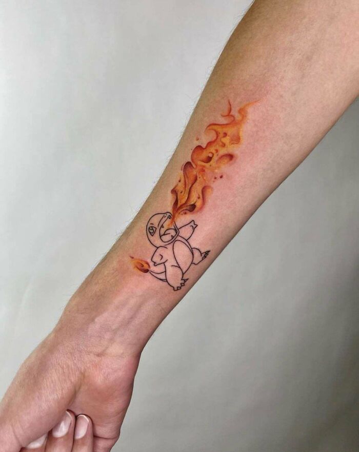 Creative tattoo design featuring a fire-breathing creature on a forearm, showcasing artistic excellence.