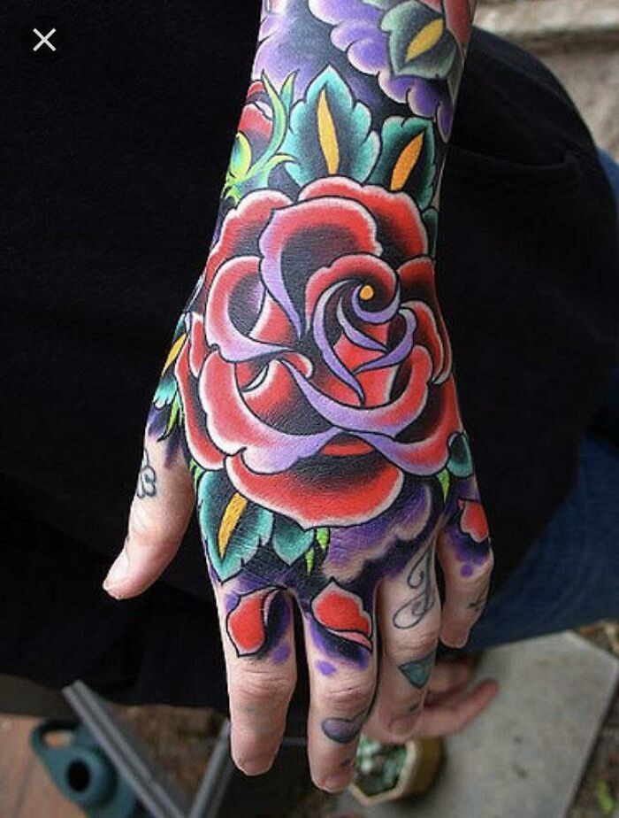 Colorful floral hand tattoo design showcasing elaborate artistry.