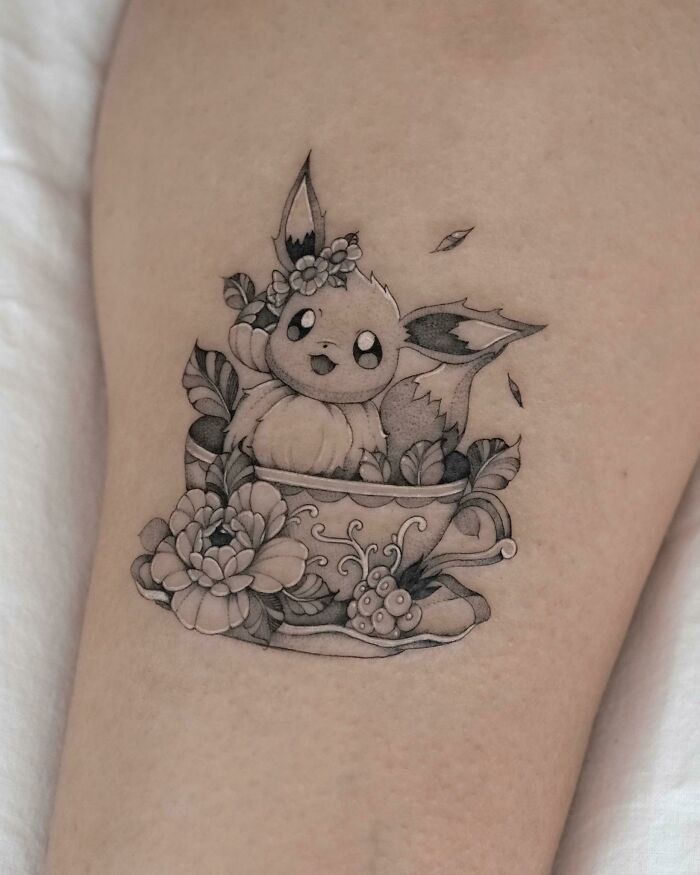Tattoo design of a cute creature in a floral teacup, showcasing artistic detail and creativity.