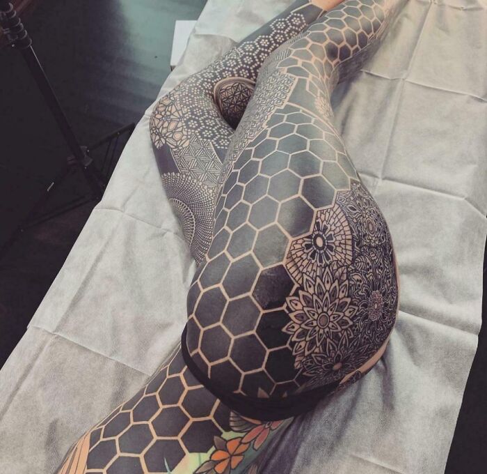 Intricate geometric tattoo design covering legs, showcasing a tattoo artist's exceptional skill.