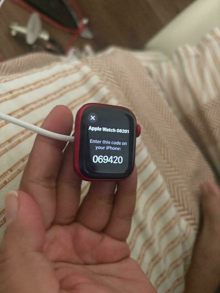 Hand holding Apple Watch with a code displayed, illustrating a coincidence moment captured in a photo.
