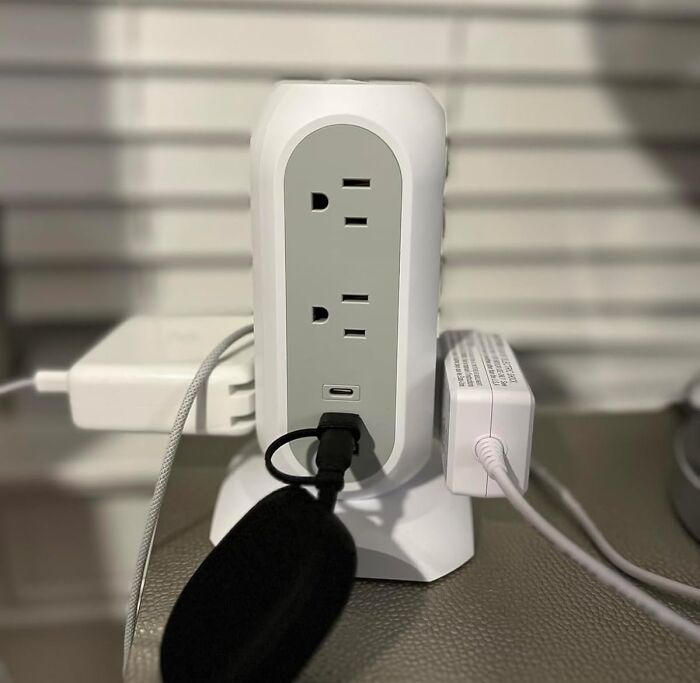 Power strip with multiple plugs and USB ports on a desk, essential for office productivity.