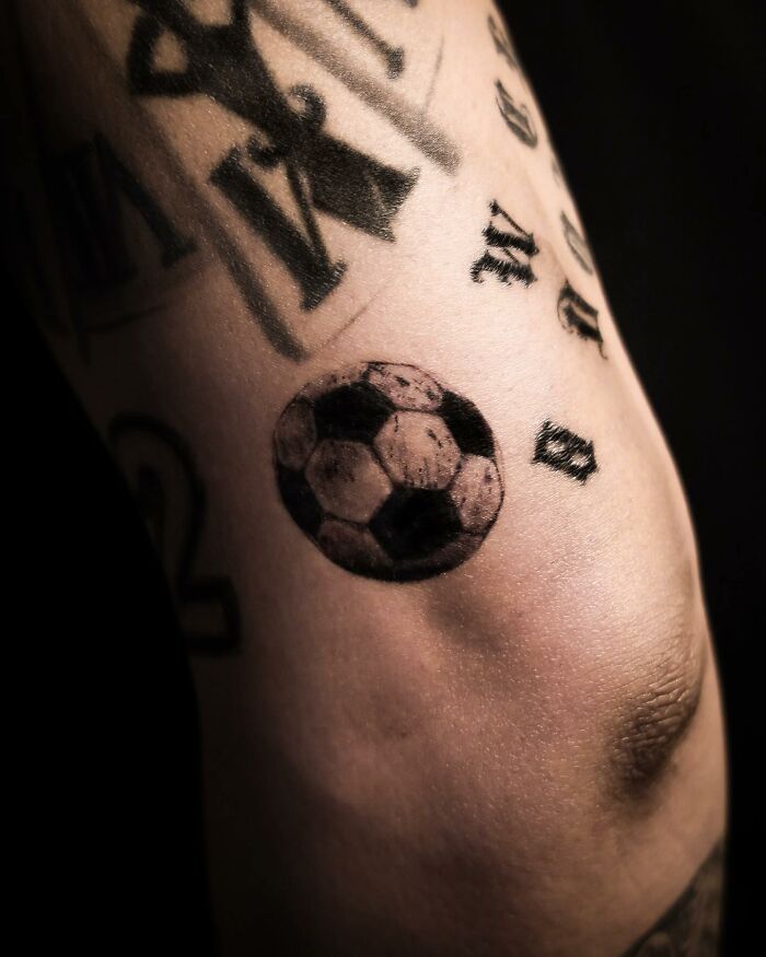 Hyperrealistic tattoo of a soccer ball on an arm, showcasing photorealism in tattoo artistry.
