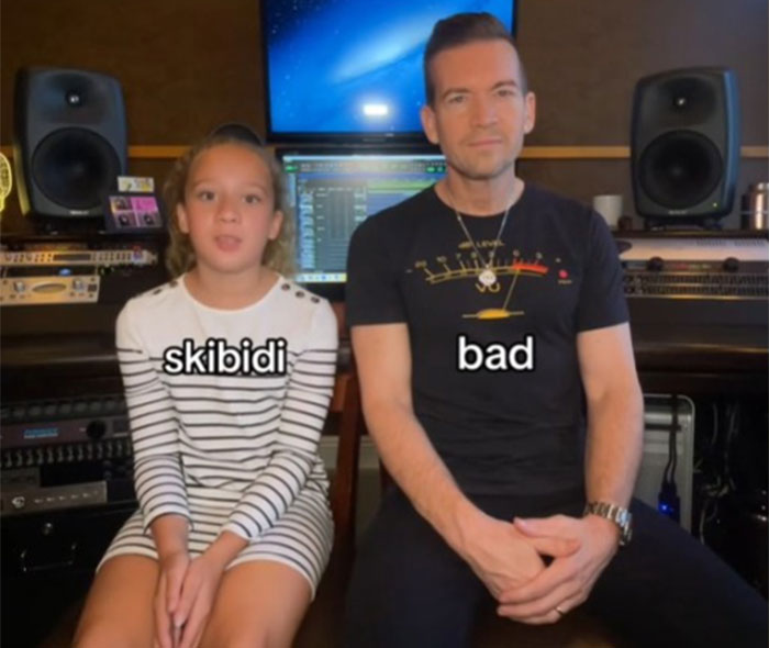 Dad and daughter in a studio. Daughter teaches dad slang terms "skibidi" and "bad.