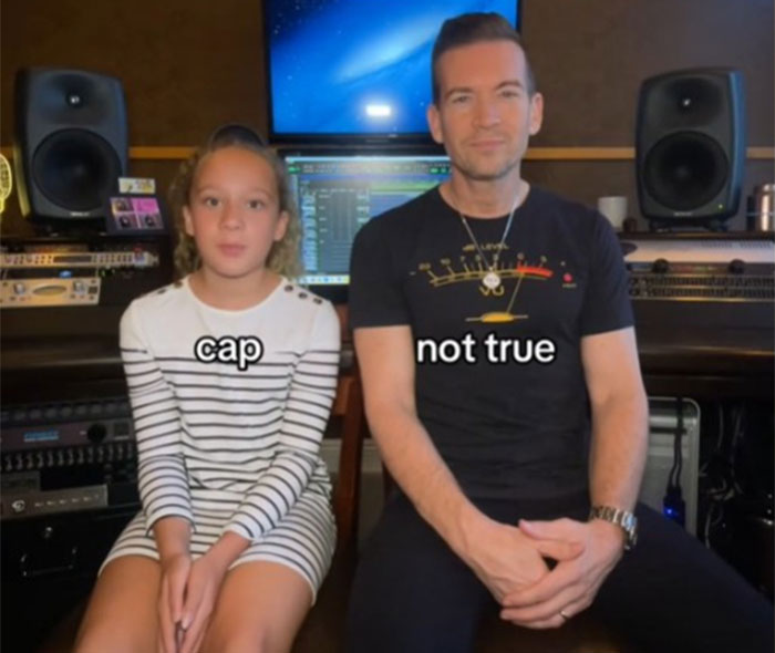 Father and daughter sitting in a studio, discussing Gen Alpha slang terms, with captions "cap" and "not true.
